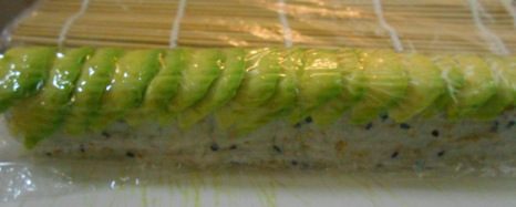 cover the roll and avocado with saran wrap