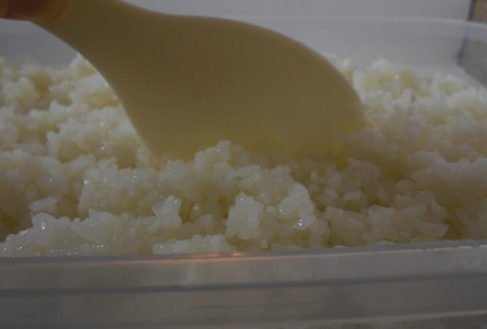 use rice paddle to mix in the sushi seasoning